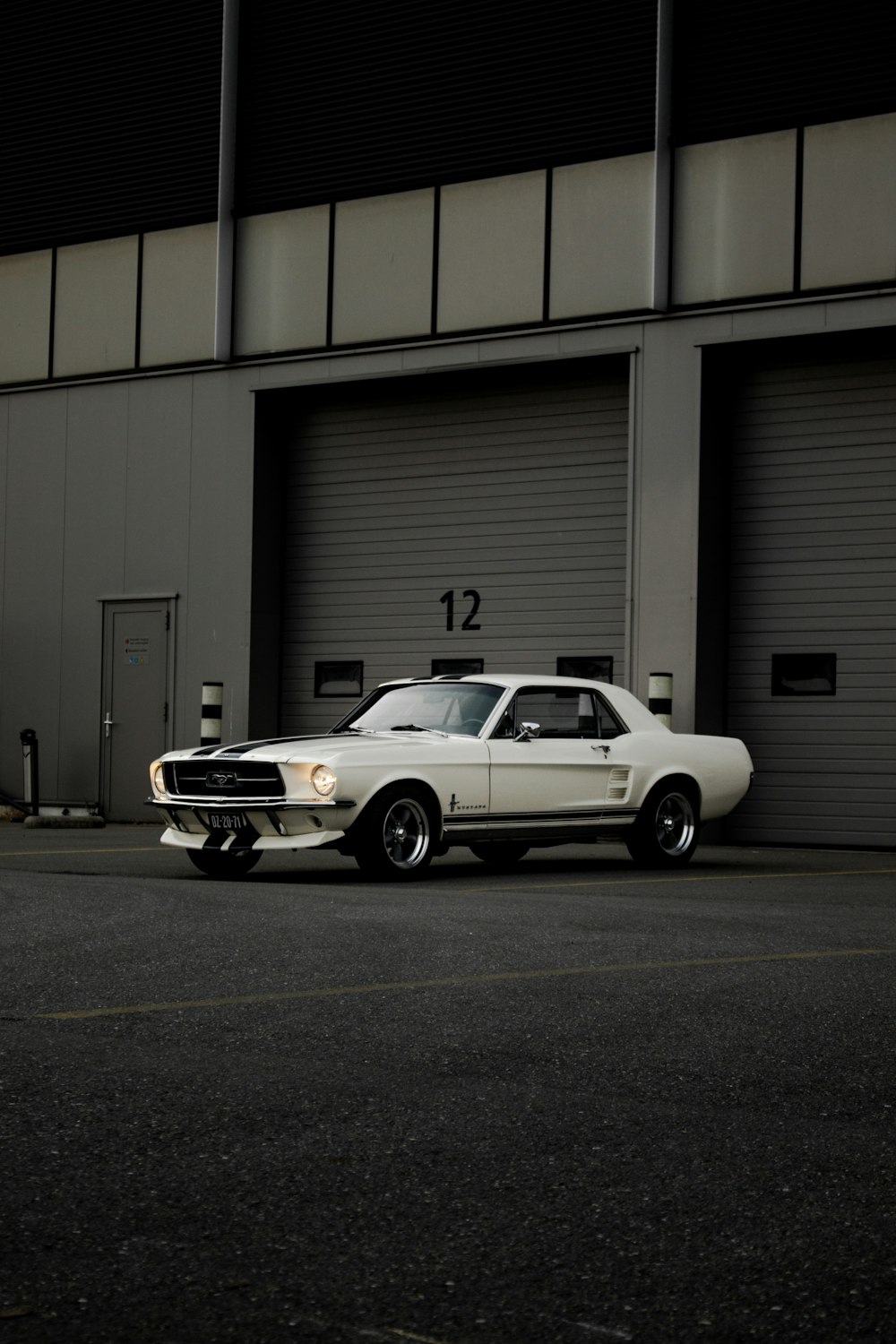 Chevrolet Camaro blanco estacionado frente al garaje