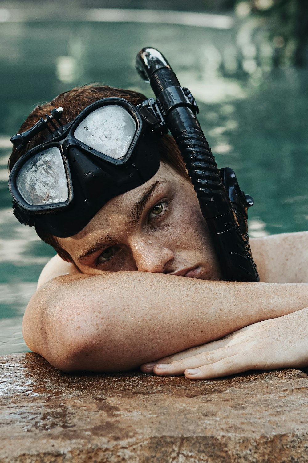 man wearing black goggles on swimming pool during daytime