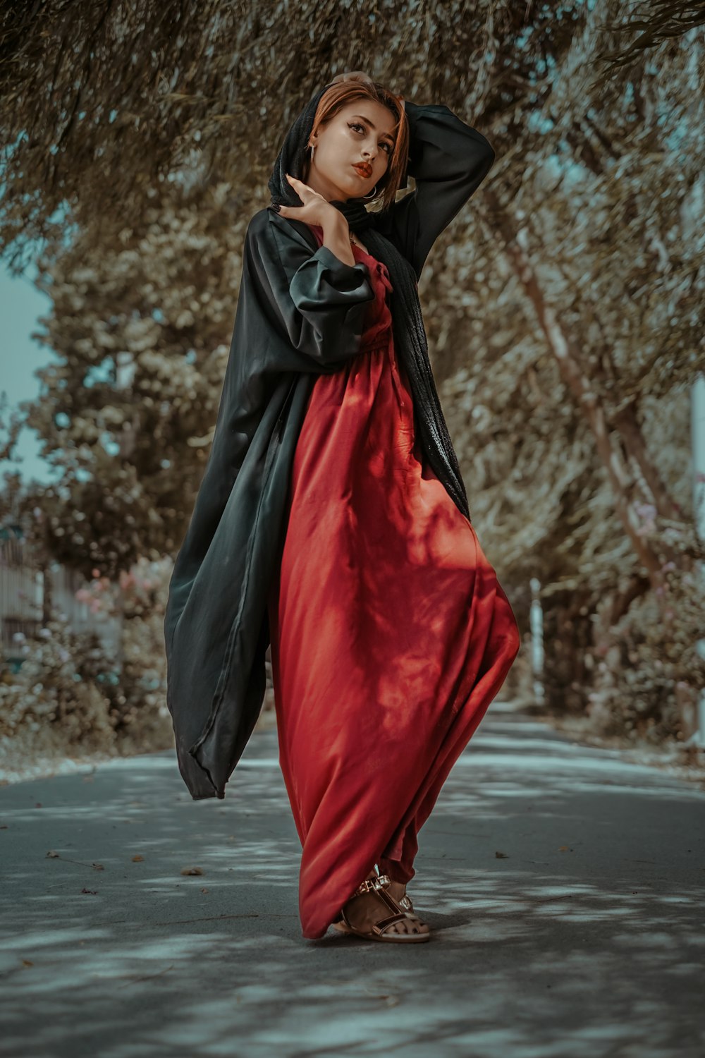 woman in black and red dress standing on road during daytime