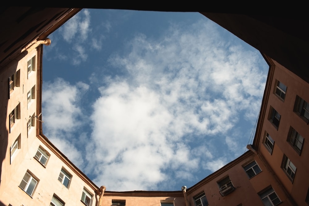 brown concrete building under blue sky and white clouds during daytime