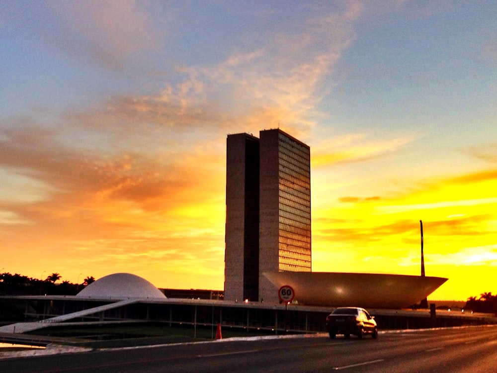 cars on road near city buildings during sunset