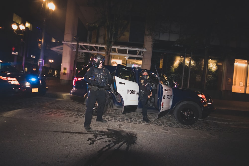 man in black jacket and black pants walking on sidewalk during night time