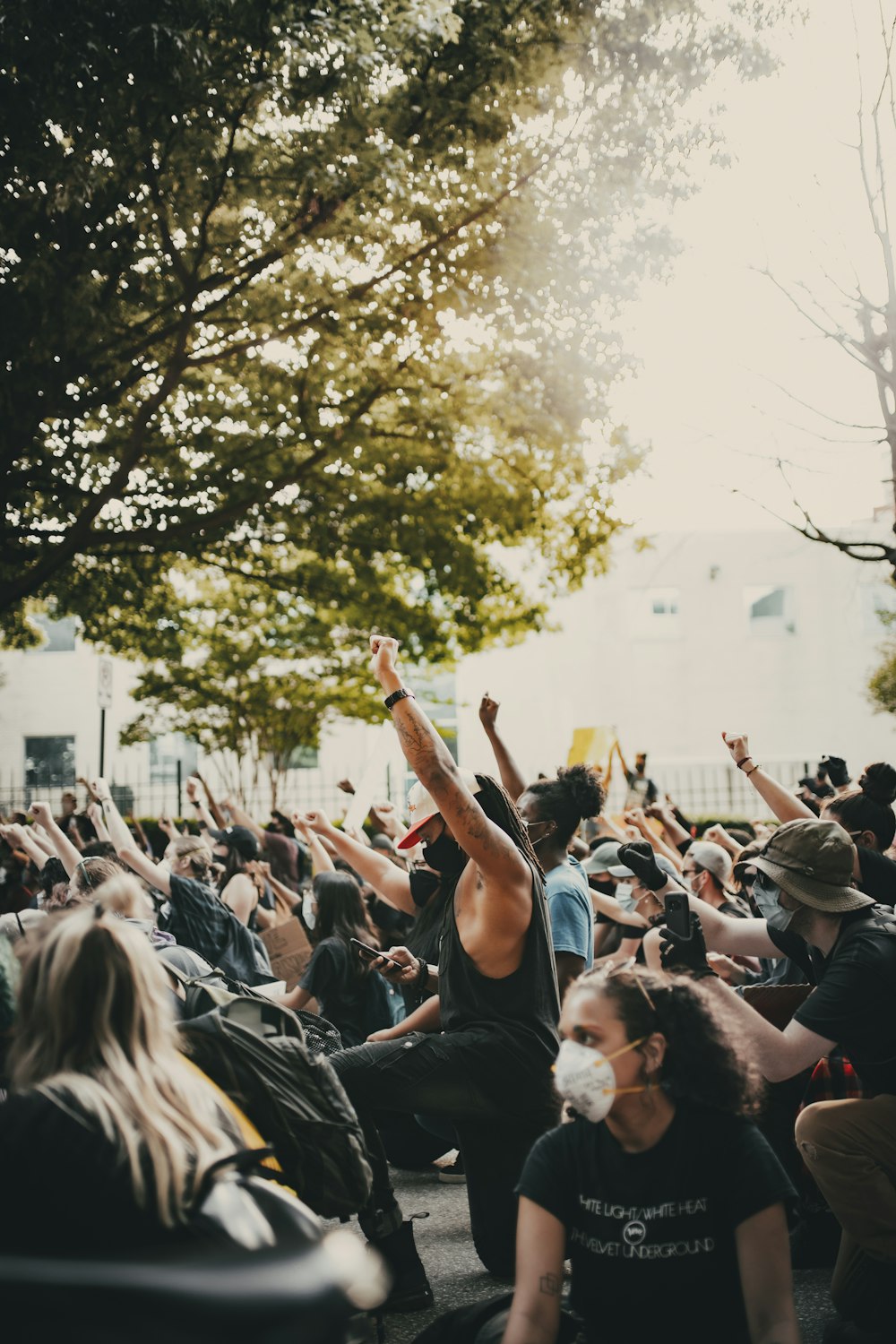 people standing and raising their hands during daytime