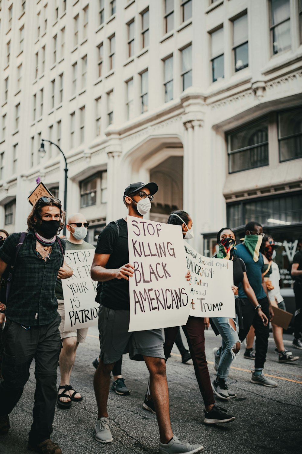 man in black jacket holding white and black banner