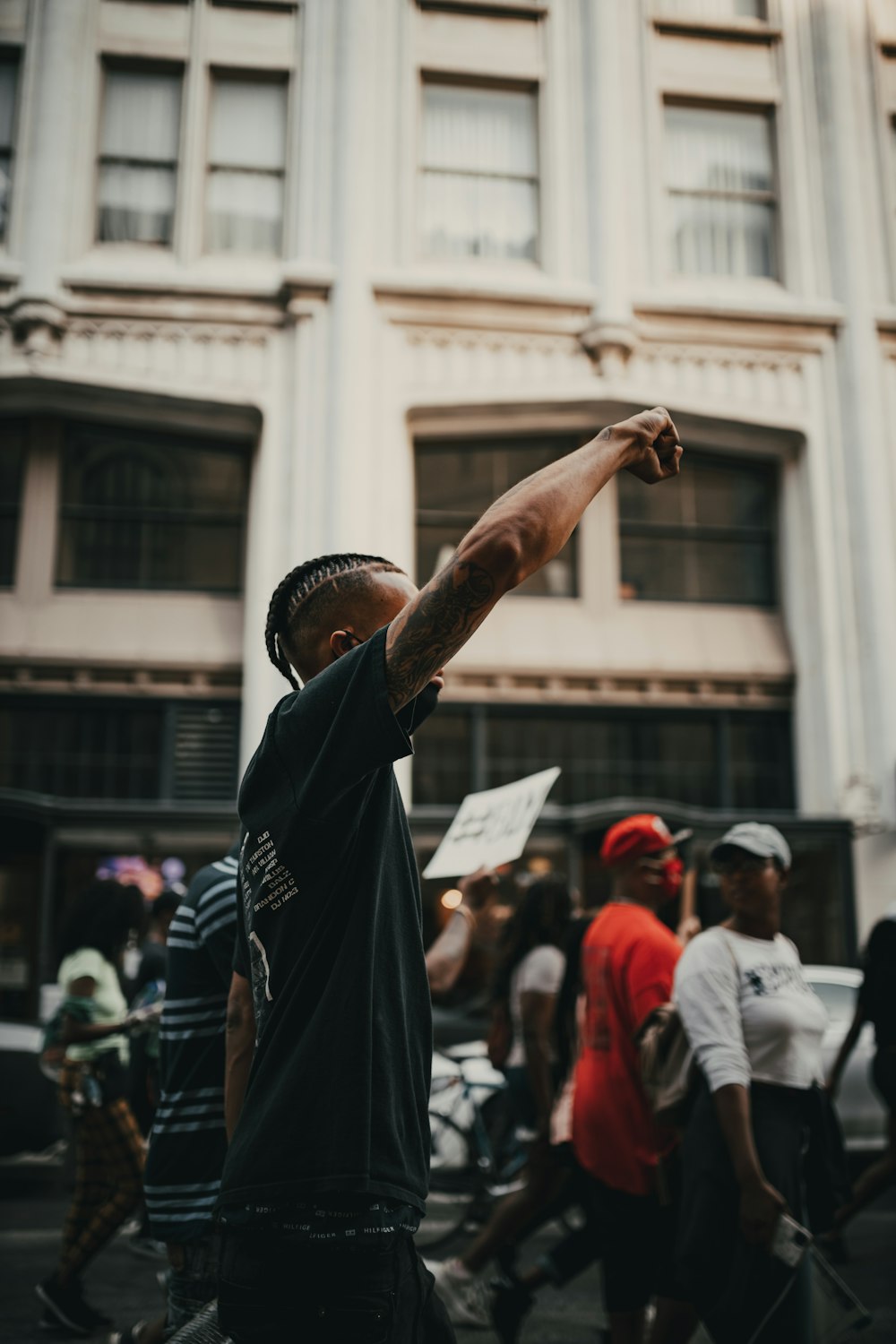 man in black shirt raising his right hand