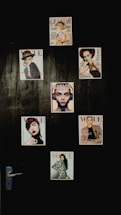 A collection of magazine covers is displayed on a dark wall, each featuring a different portrait of a person. The covers are from well-known fashion magazines such as Vogue, Grazia, and Elle. The arrangement is aesthetically pleasing and suggests a focus on fashion and style.