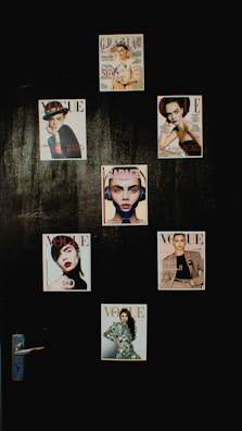 A collection of magazine covers is displayed on a dark wall, each featuring a different portrait of a person. The covers are from well-known fashion magazines such as Vogue, Grazia, and Elle. The arrangement is aesthetically pleasing and suggests a focus on fashion and style.