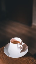 A warm coffee cup on a black and white table with subtle orange and light green accents.