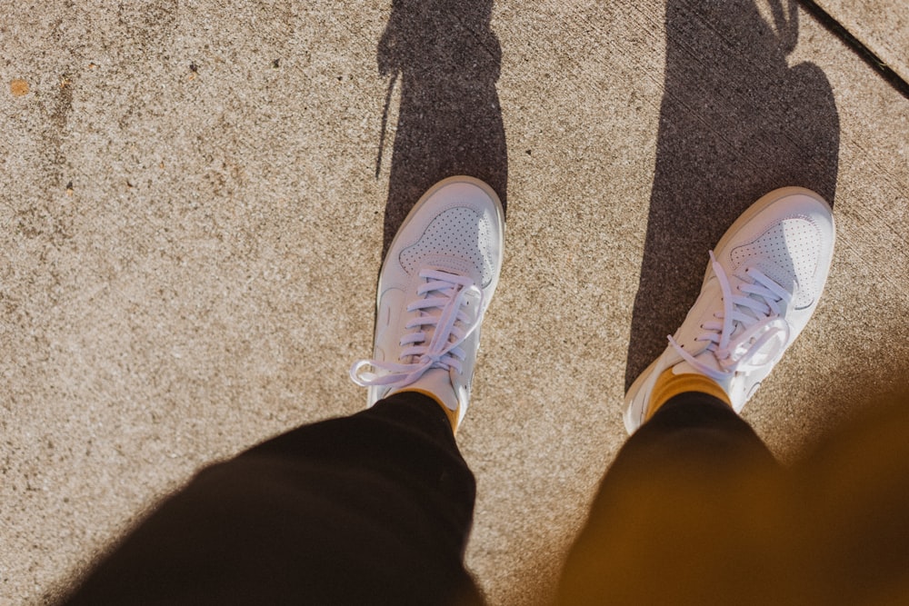 Person in grauen und weißen Nike-Sportschuhen