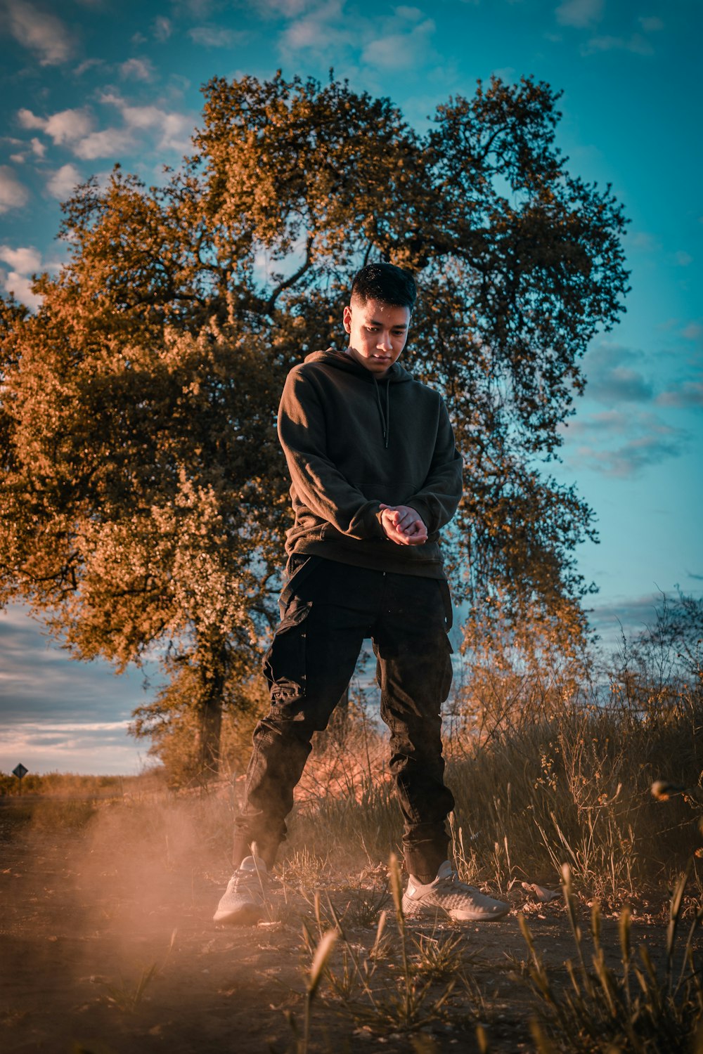 man in black jacket standing near tree during daytime