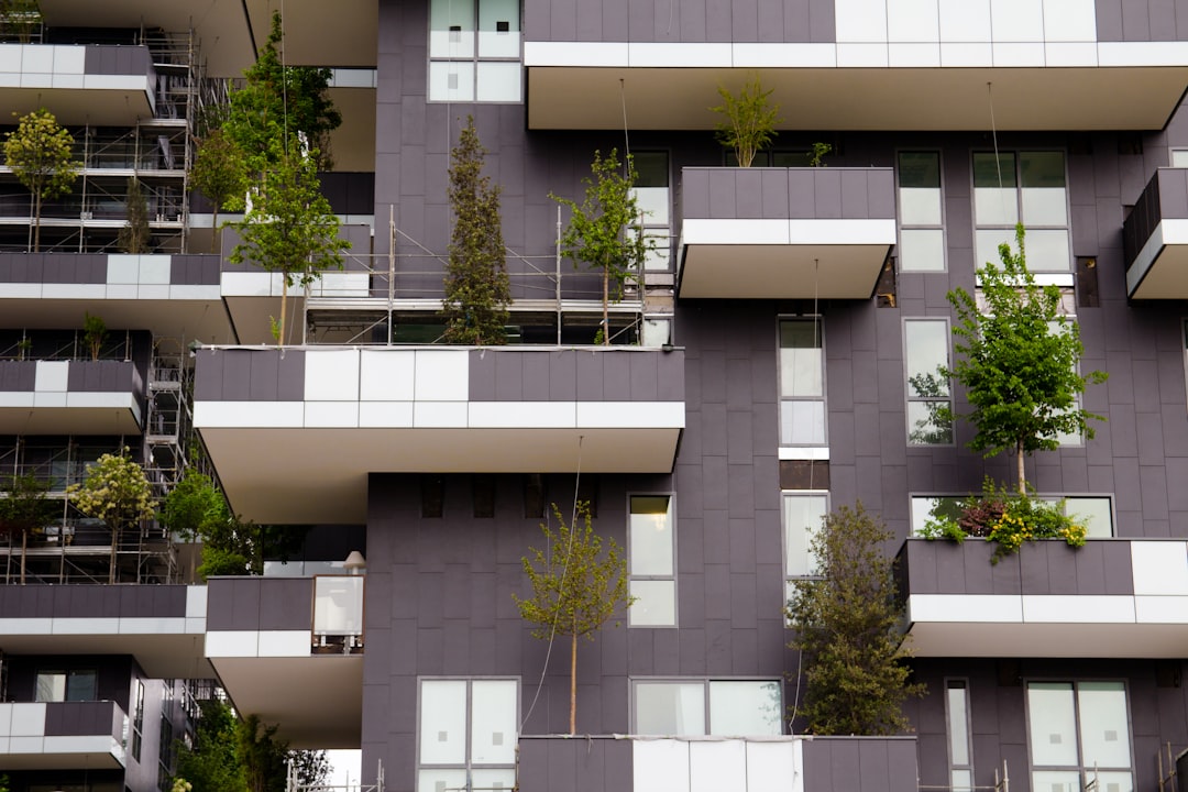 green trees in front of white concrete building,