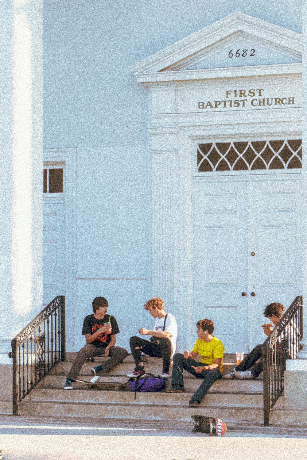 group of people sitting on black wooden bench