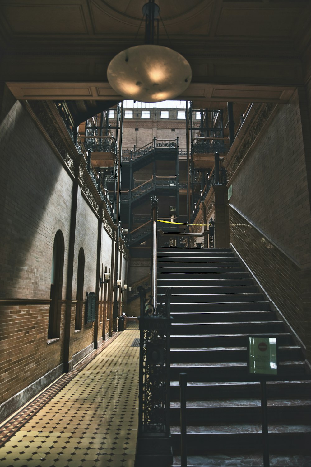 Escalera de madera marrón con cubo de basura verde