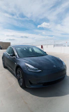Tesla Model Y parked outside Eastvale airport terminal at sunset.