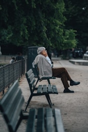 man in brown jacket sitting on bench
