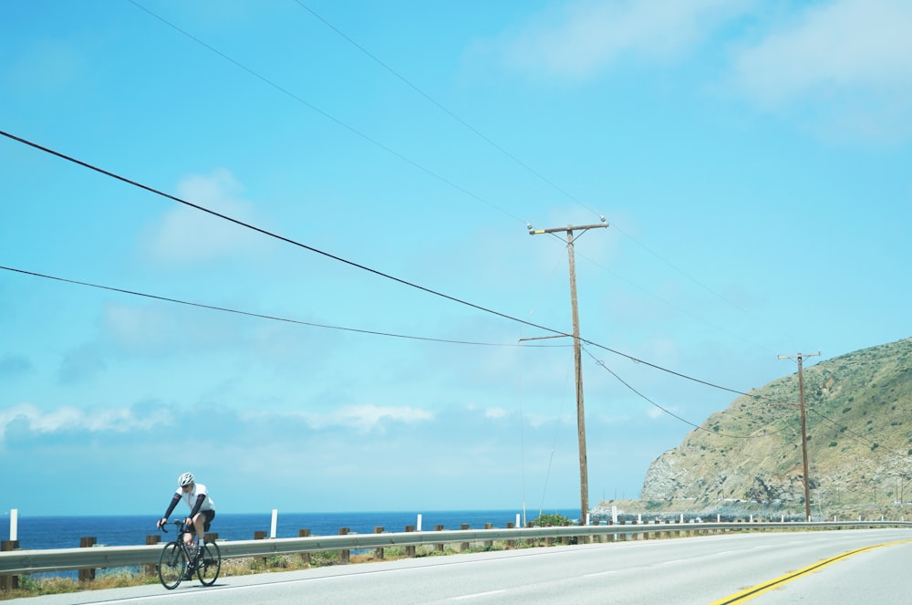 man in black jacket riding bicycle on road during daytime