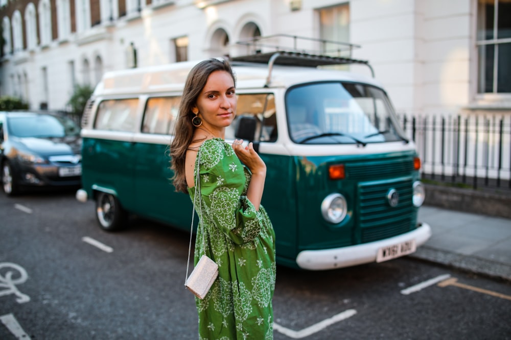 woman in green floral dress standing on sidewalk during daytime