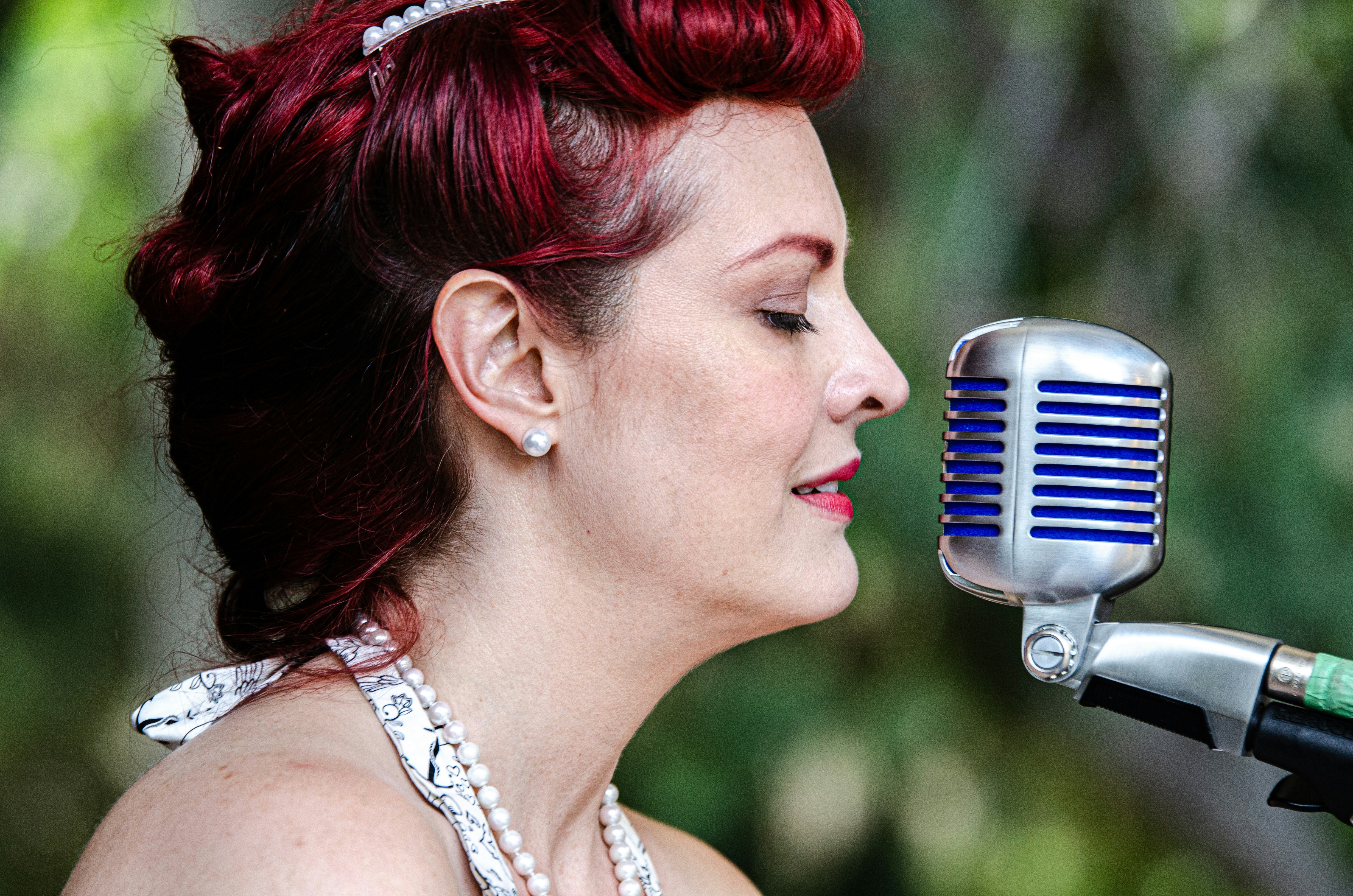 woman in white pearl necklace and silver hoop earrings