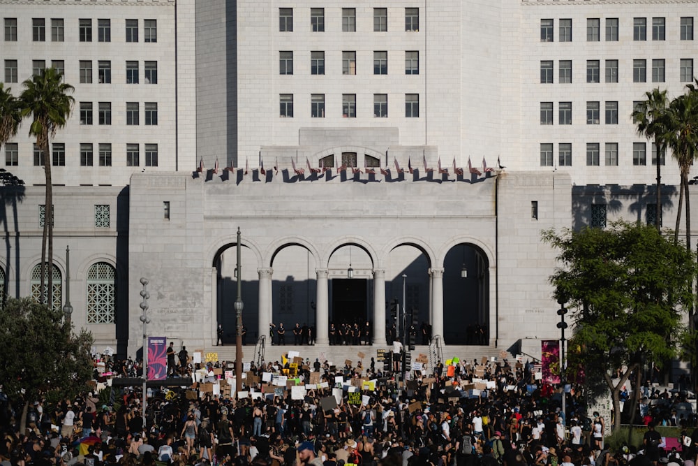 people in front of white concrete building during daytime