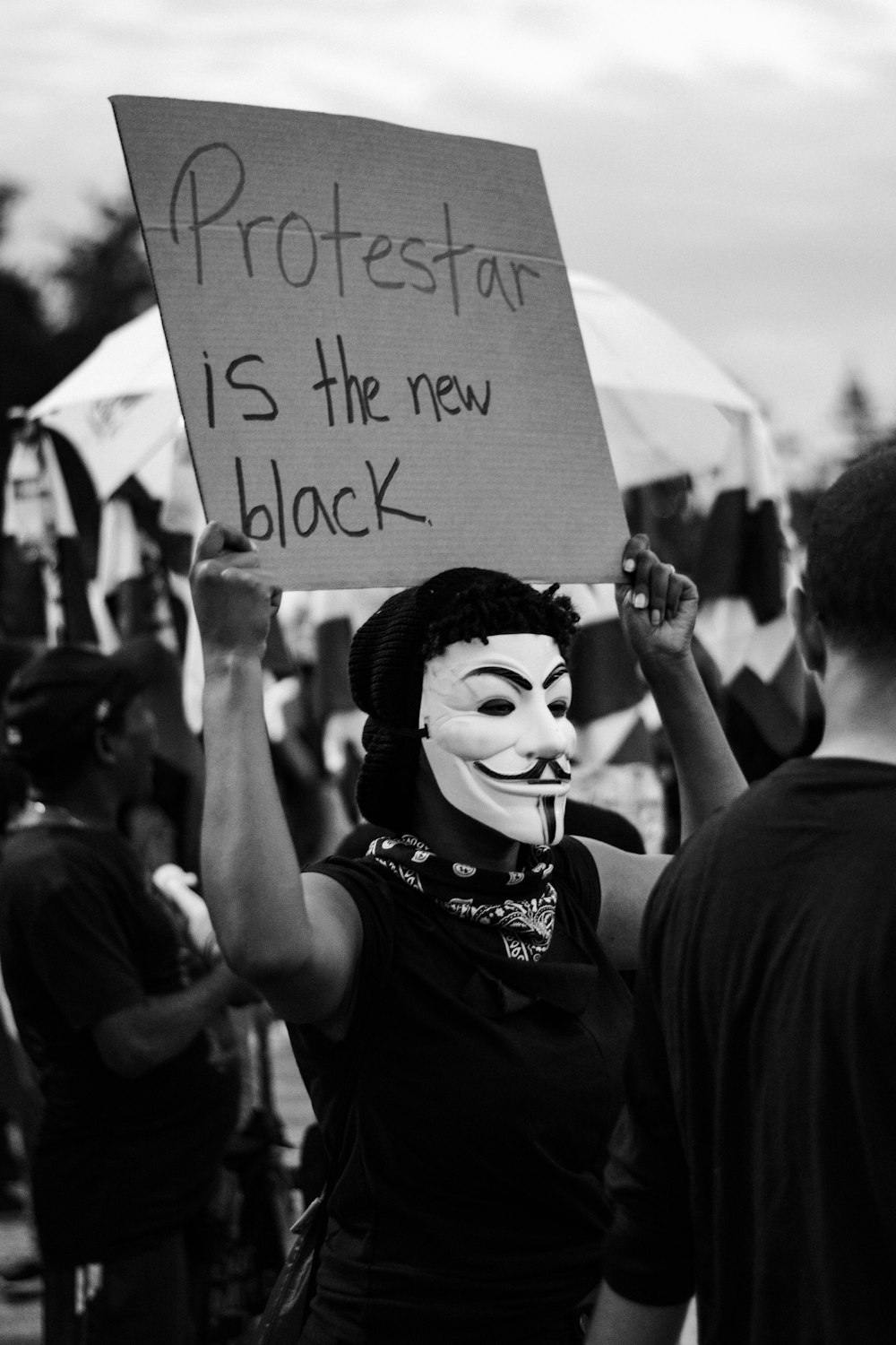 grayscale photo of man holding paper with hand written texts