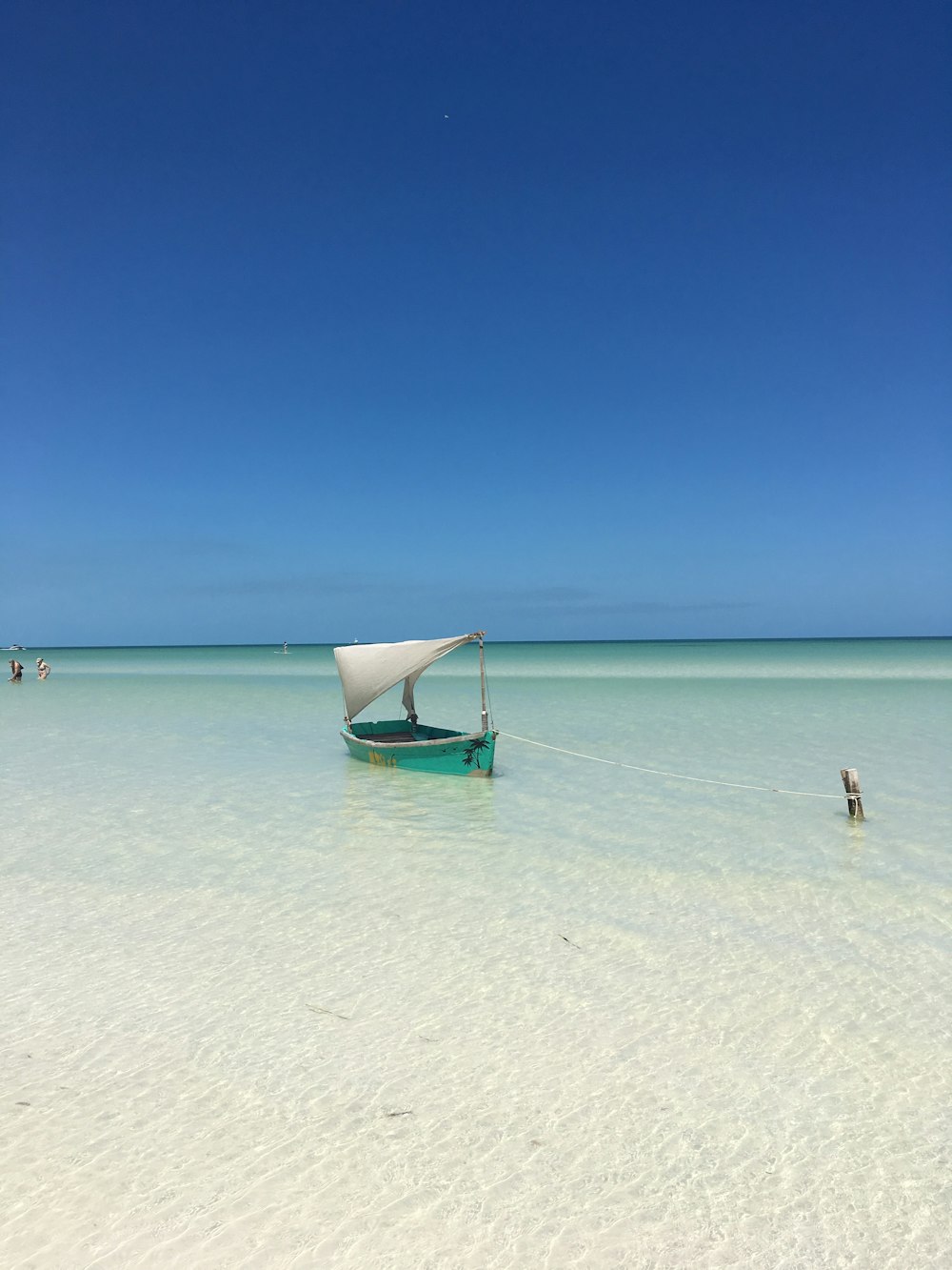 blue boat on sea under blue sky during daytime