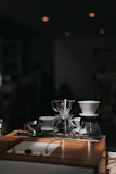 Modern coffee grinder and brewing tools arranged neatly on a white countertop.