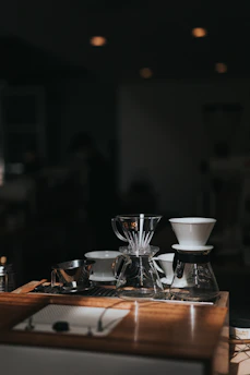 Various coffee brewing accessories arranged neatly on a dark wooden surface.