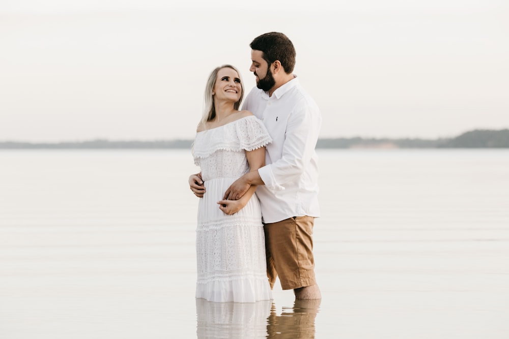 man and woman standing on water during daytime