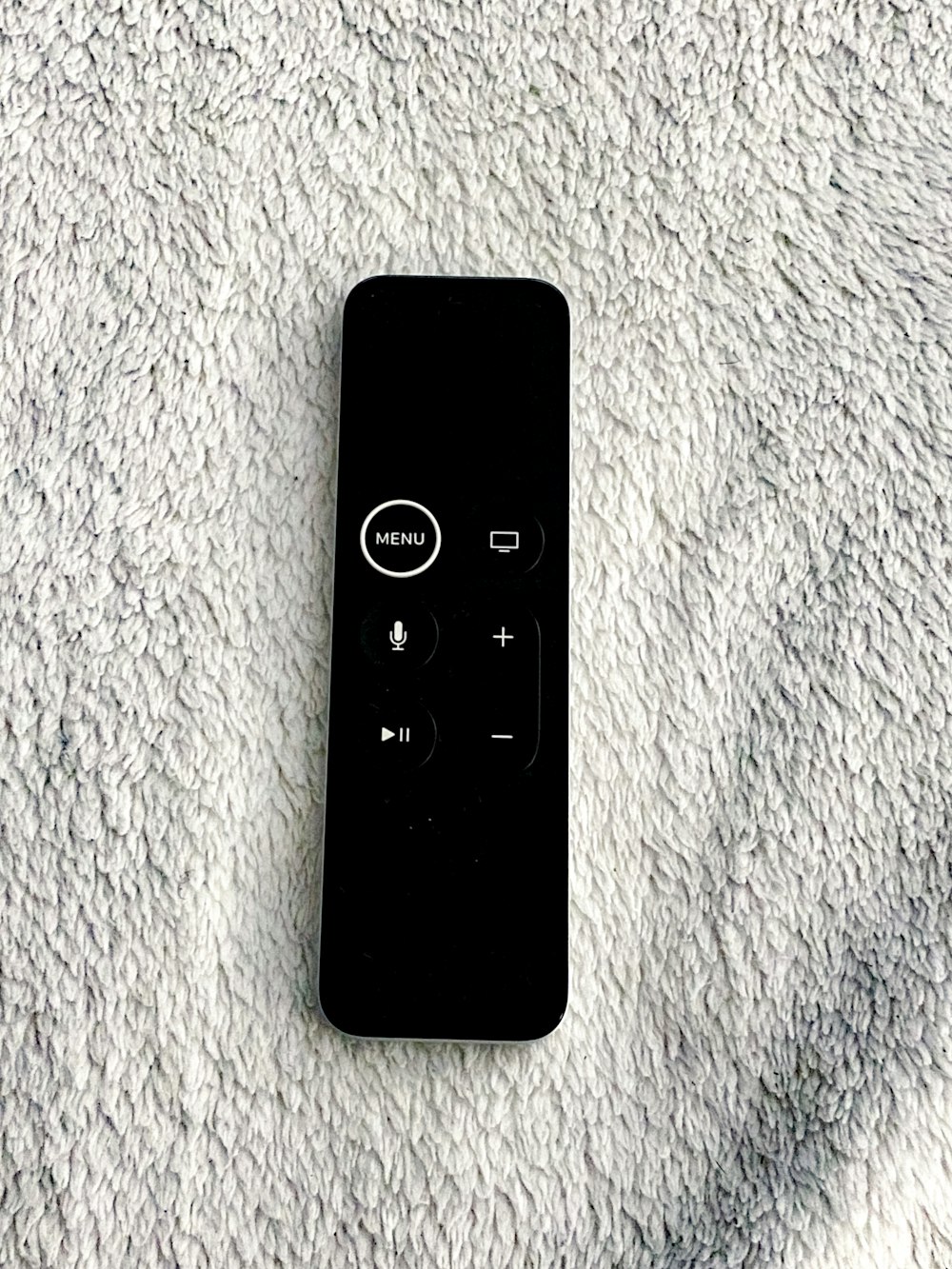 black remote control on white textile