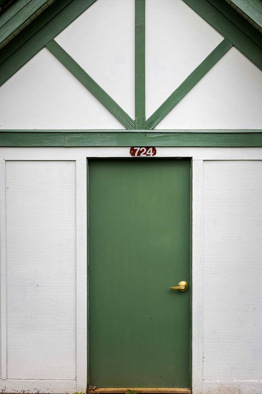 green wooden door with brass door knob