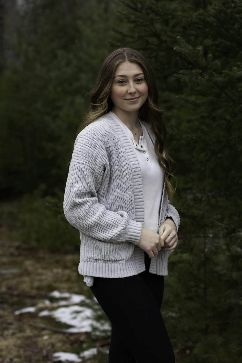 woman in gray long sleeve shirt and black pants standing on brown soil during daytime