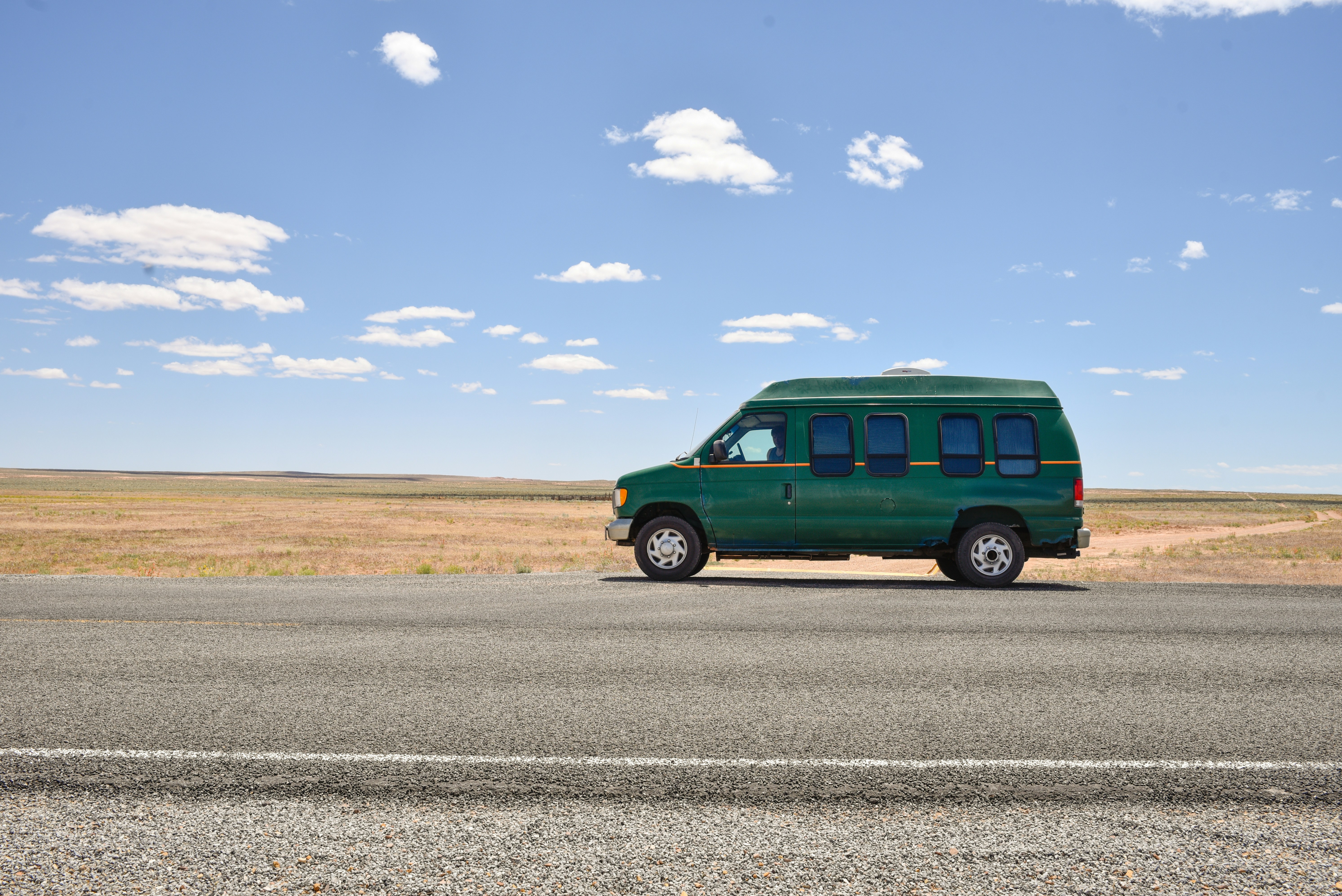 Van in the middle of nowhere on a bright sunny day in Utah.