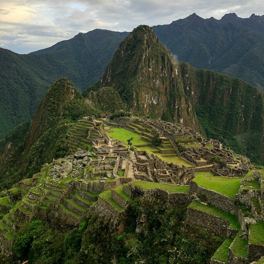 montaña verde y marrón bajo el cielo blanco durante el día