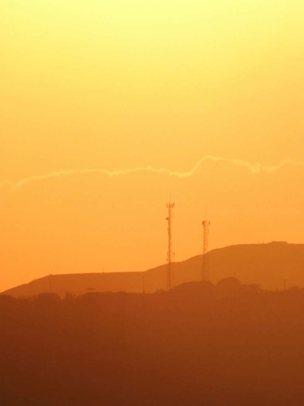 silhouette of wind turbines during sunset