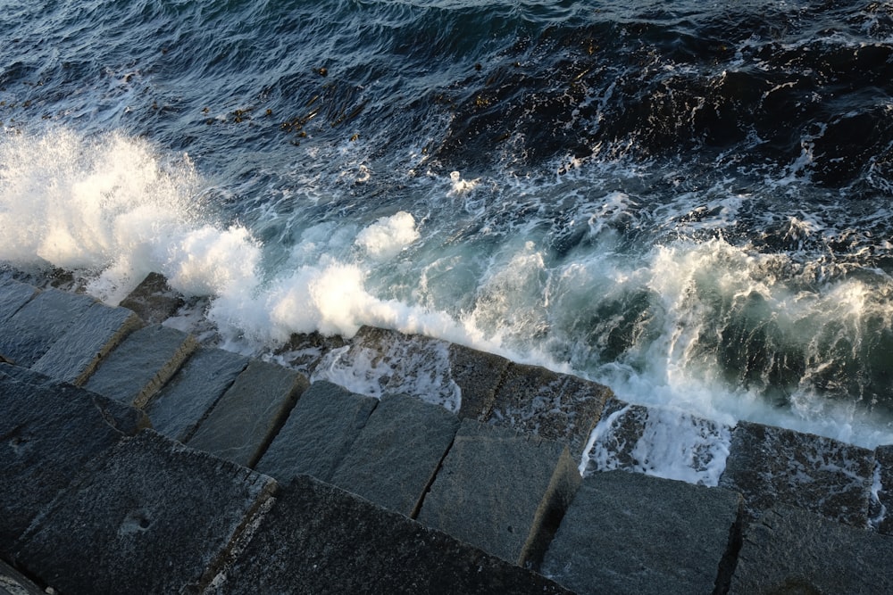 water waves hitting the concrete wall