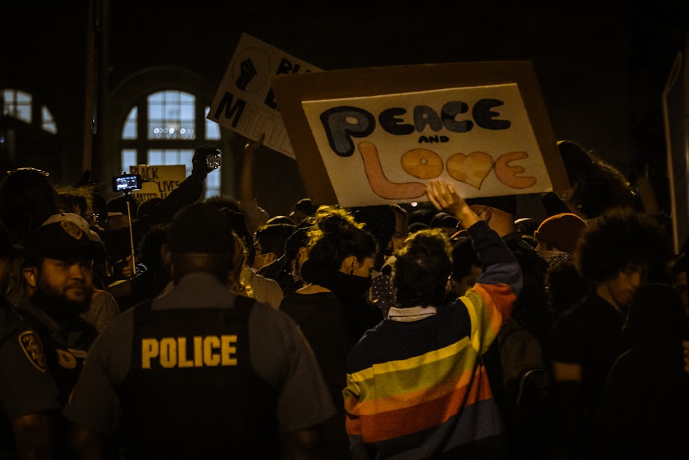 people standing and standing near white and red signage during night time