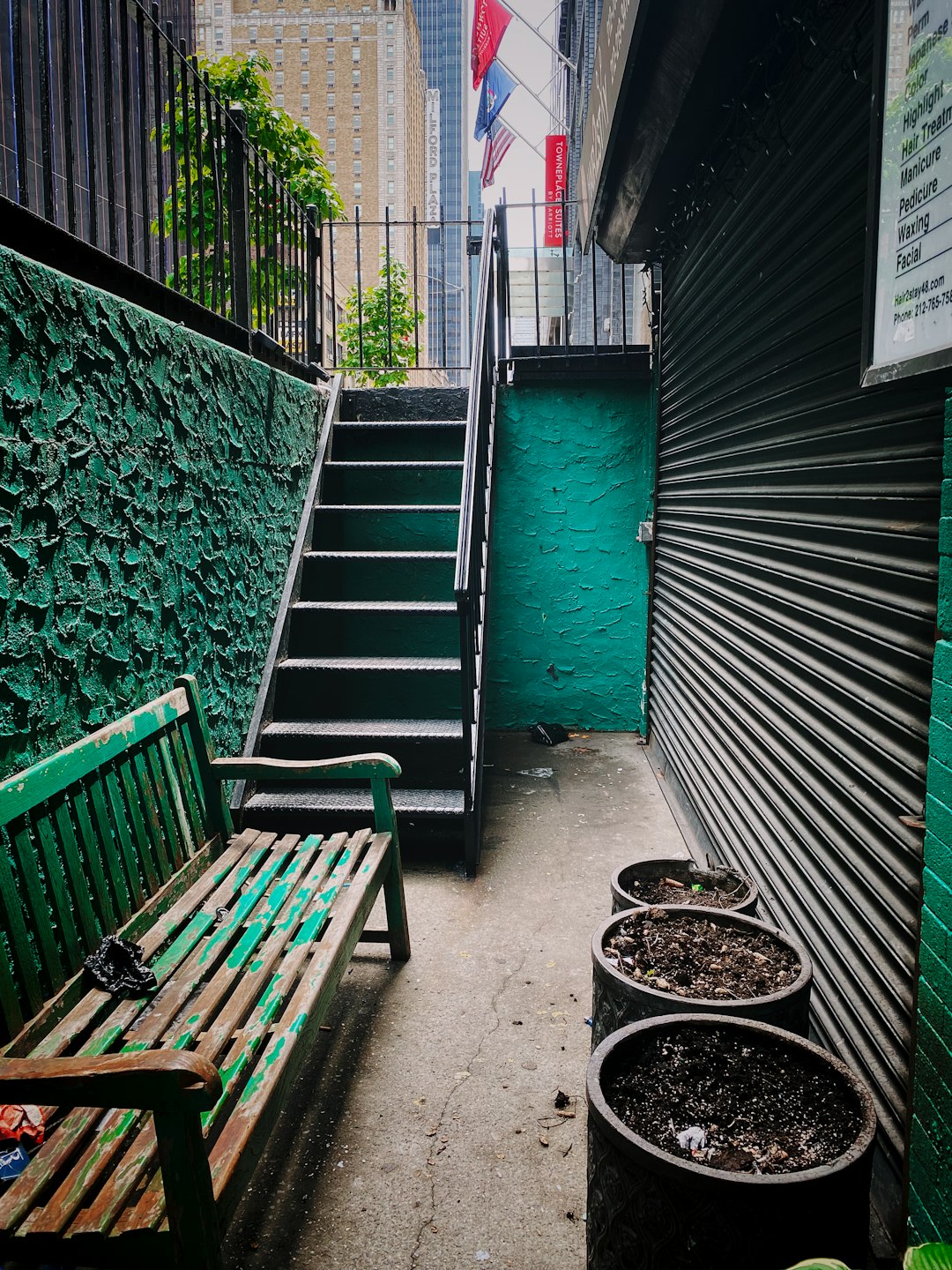 green wooden bench beside green wall