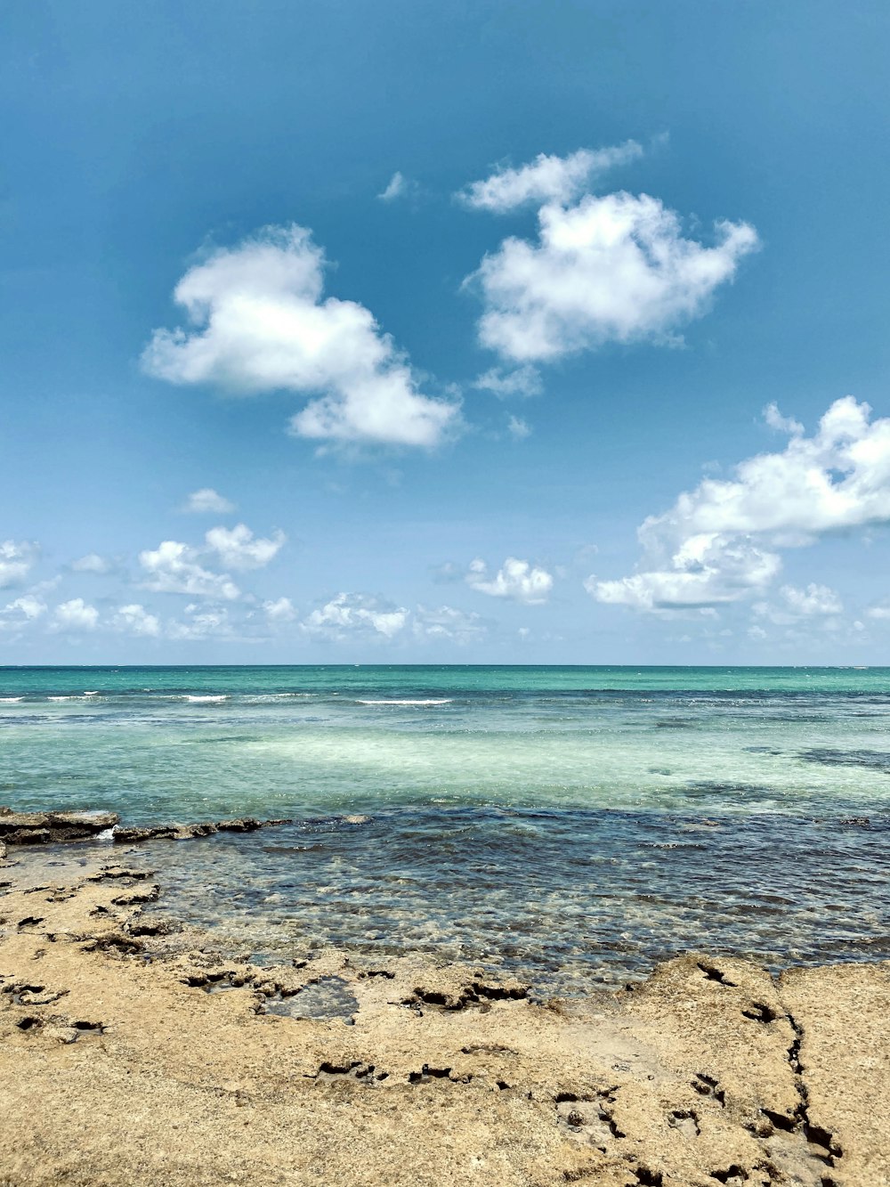 Mer bleue sous ciel bleu et nuages blancs pendant la journée