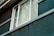Close-up of modern windows installed on a residential house with teal accents.