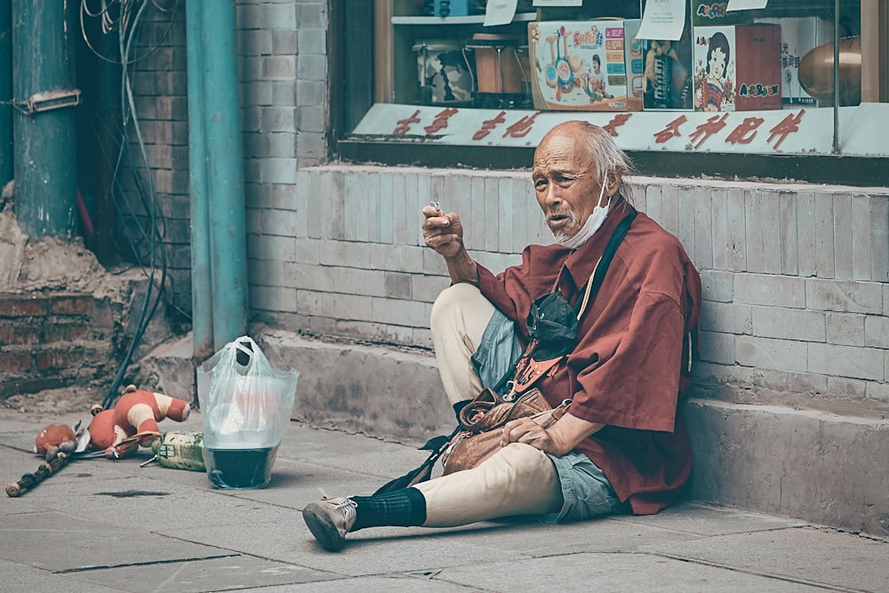 man in red robe sitting on floor