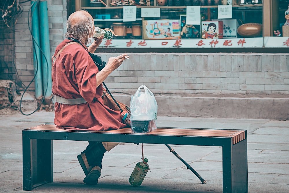 man in red robe sitting on brown wooden table