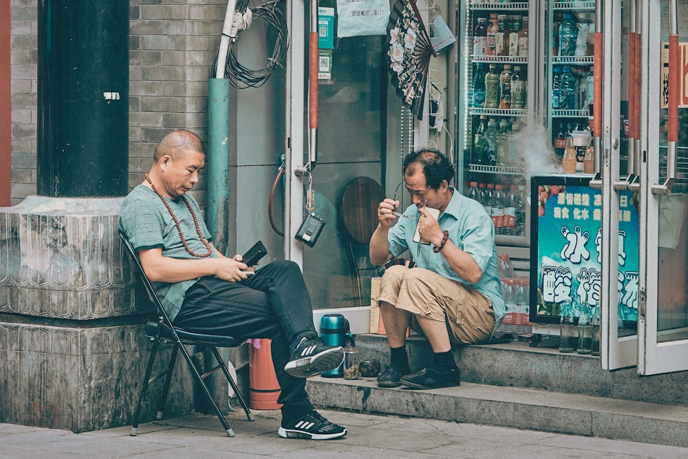 man in gray shirt sitting on chair beside woman in gray shirt