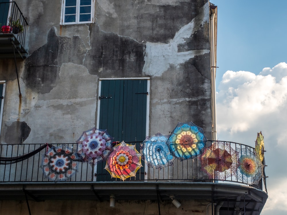 blue pink and yellow umbrella on gray concrete wall