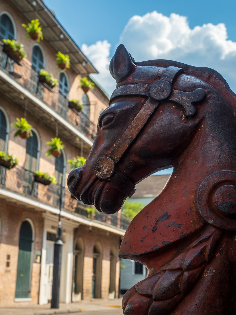 Estatua de caballo de madera marrón cerca de un edificio de hormigón marrón durante el día