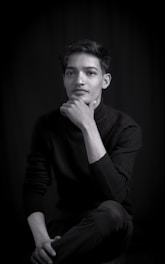 A minimalist dark-mode portrait of Dr. Bereket A. Yilma working thoughtfully at his desk surrounded by AI and brain-computer interface sketches.