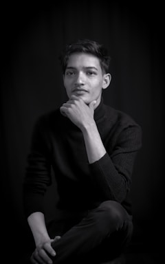 A minimalist dark-mode portrait of Dr. Bereket A. Yilma working thoughtfully at his desk surrounded by AI and brain-computer interface sketches.