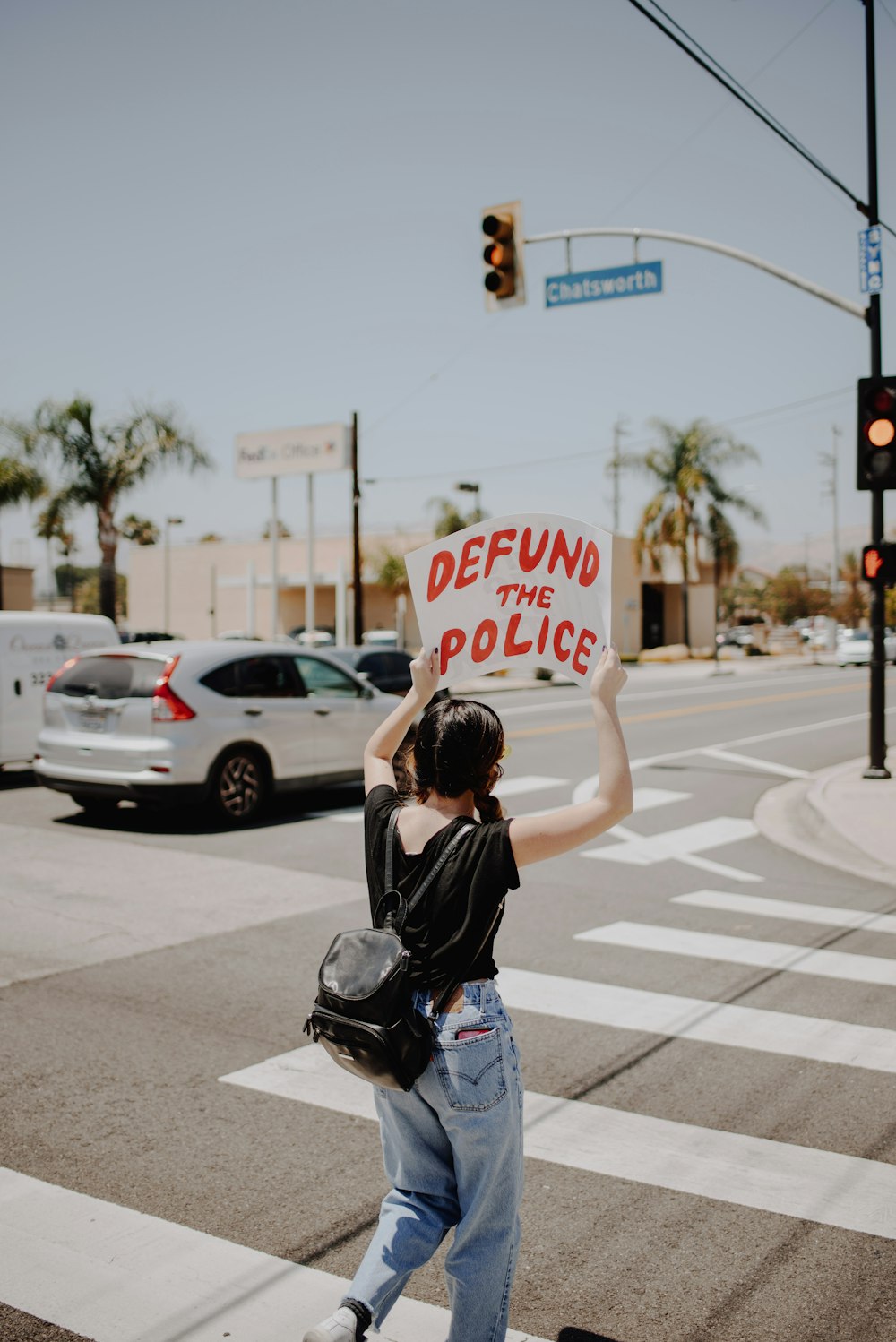 woman in black t-shirt and blue denim jeans holding stop sign