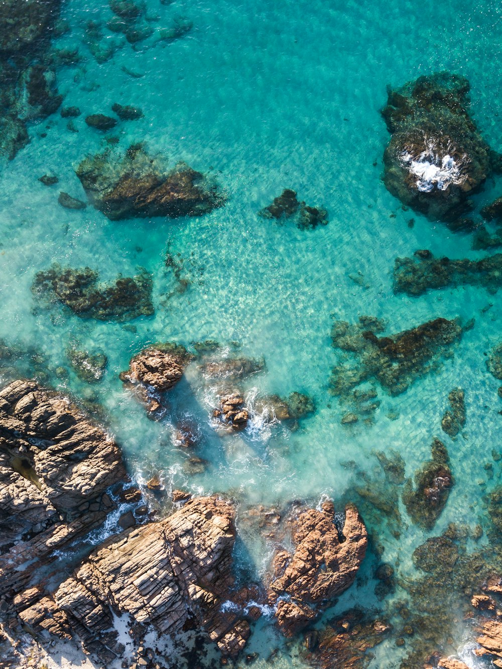 brown and black rocks on body of water