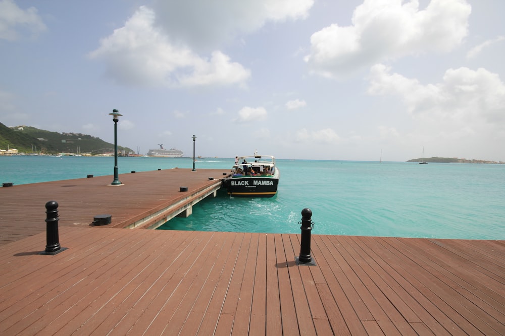 brown wooden dock on sea under blue sky during daytime