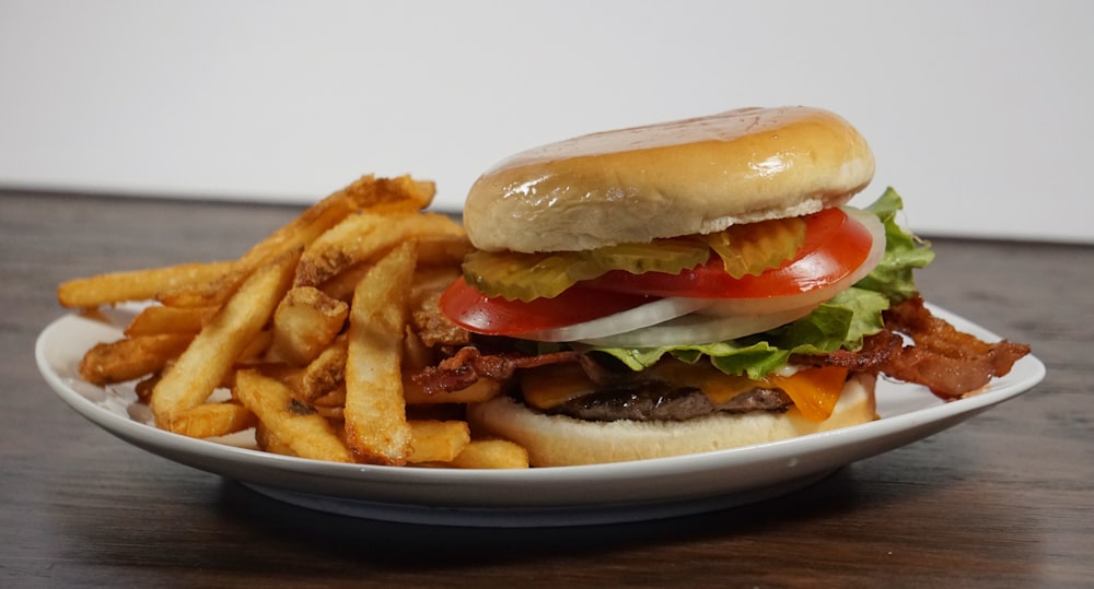 burger with tomato and lettuce on white ceramic plate